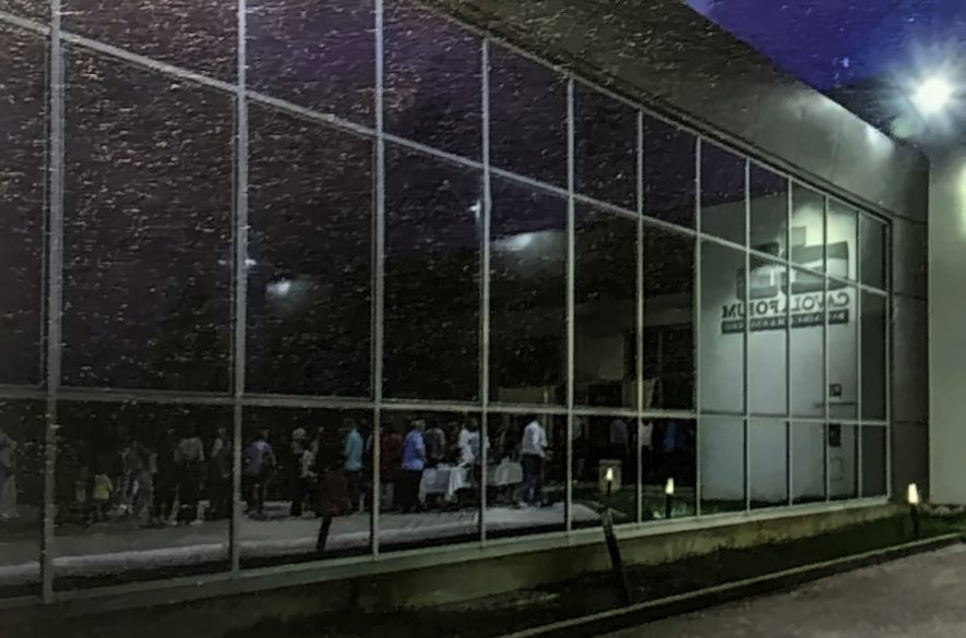 La facciata a vetri del CavolaForum illuminata di sera