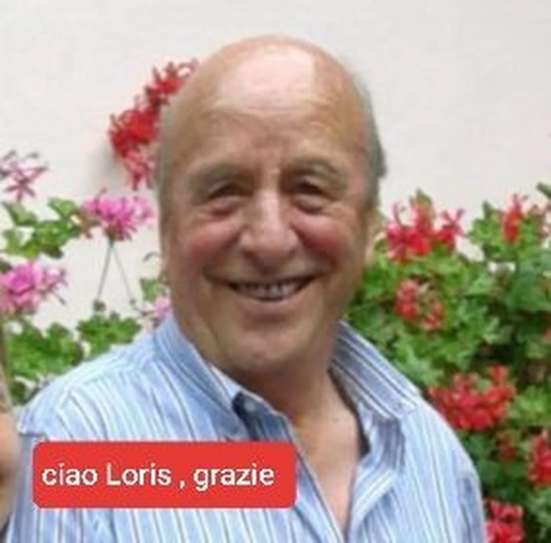 Loris sorridente davanti a un cespuglio di gerani